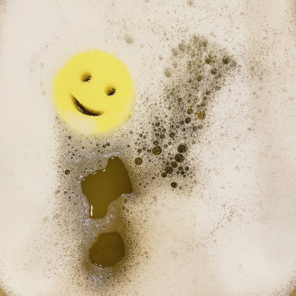 up close of sudsy dish soap with yellow scrub daddy sponge