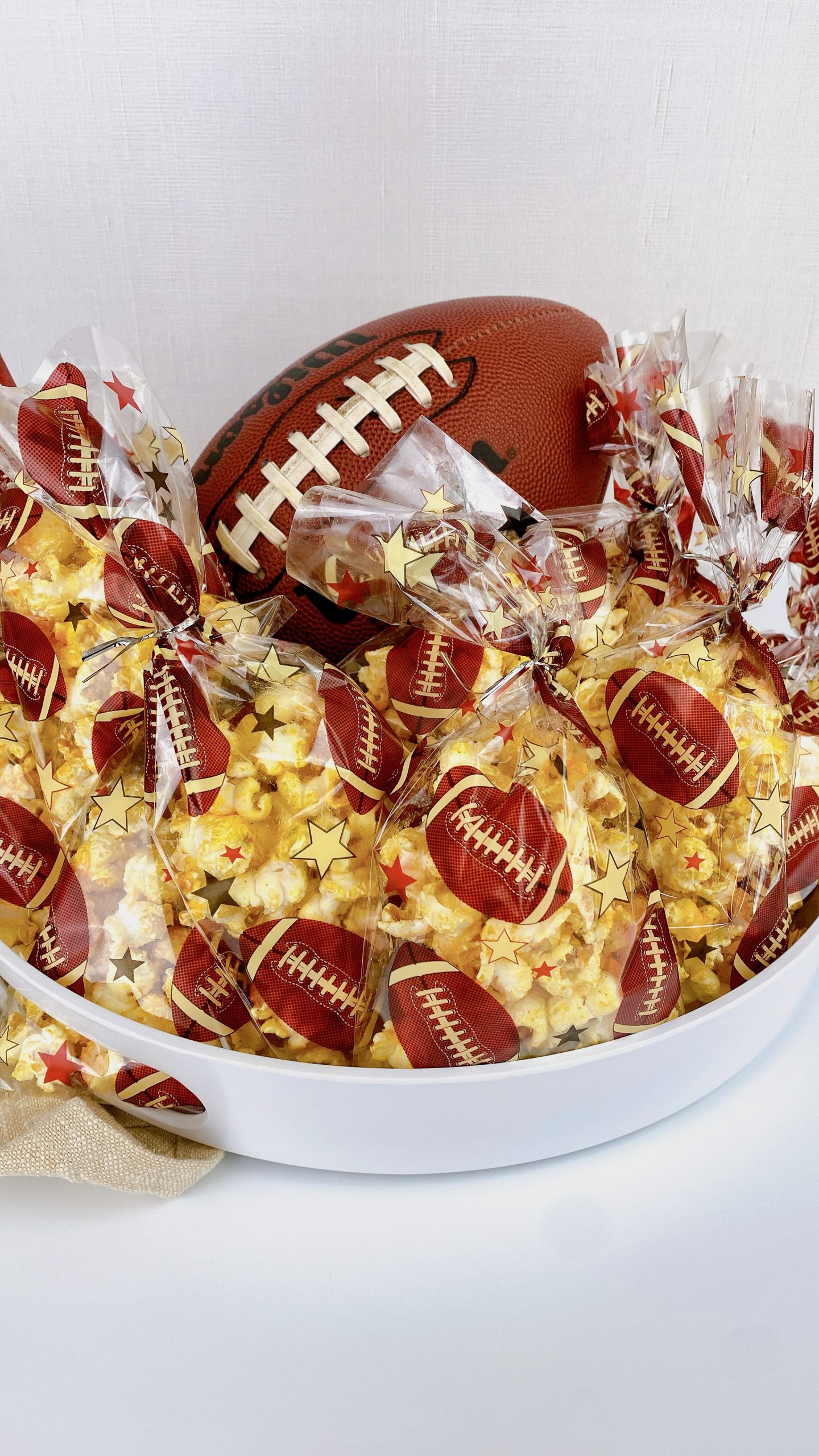 bags of popcorn in a bowl with a football